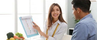 Nutritionist with measuring tape showing meal plan to client in consultation