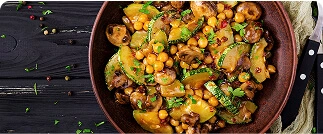 Roasted vegetable medley with chickpeas, zucchini, mushrooms, and fresh herbs in rustic bowl