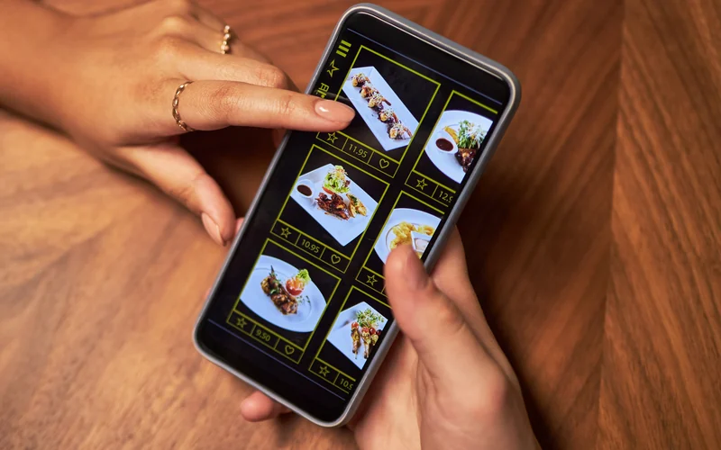 Two people browsing dish photos on a phone