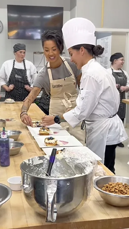 Kristen Kish working alongside an Escoffier student in a teaching kitchen.