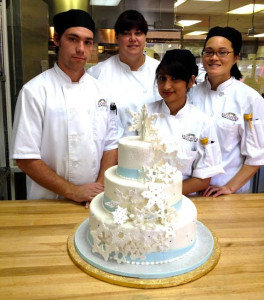 Pastry arts school students and their tiered cake