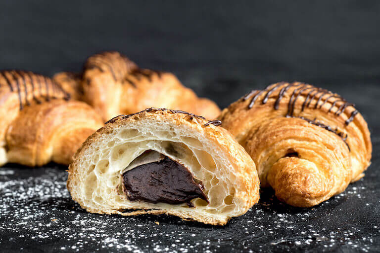 Chocolate croissant cut in half showing chocolate filling