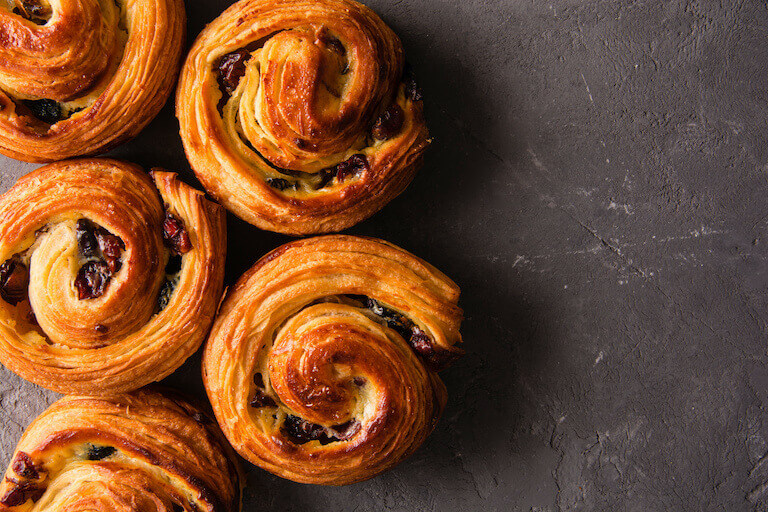 Traditional pains aux raisins sitting on a stone surface