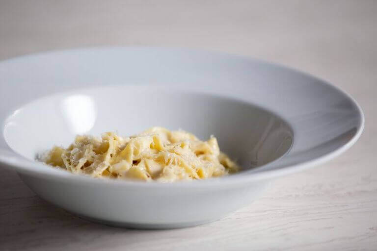Fresh fettuccine alfredo pasta dish in a white bowl