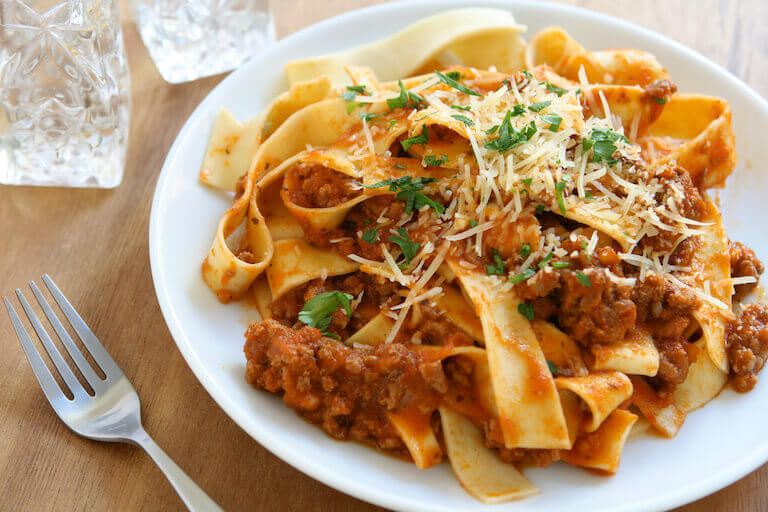 Pasta with meat Sauce and cheese on white plate