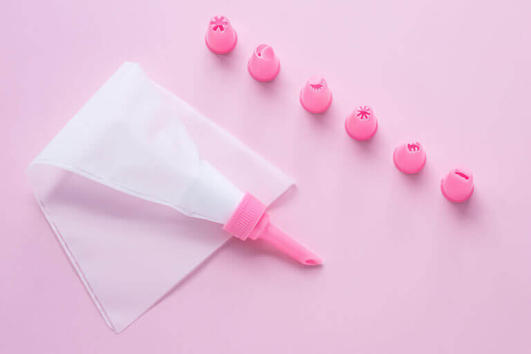 Plastic pastry bag with pink tips on a pink background