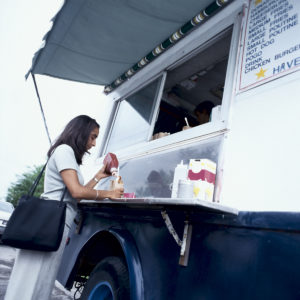 Woman with French fries and ketchup at food truck