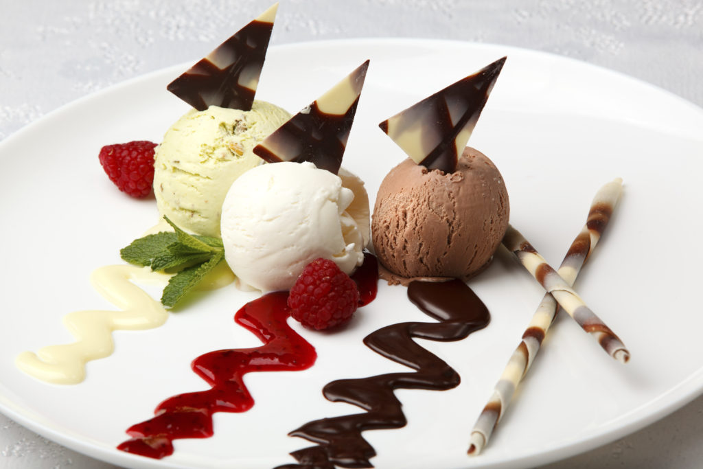 Ice cream and sorbet flavors on a plate with chocolate, strawberry and vanilla