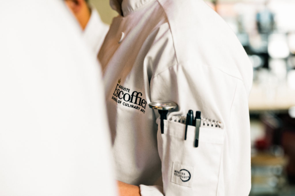 Close up of white Escoffier uniform with pens and temperature checker