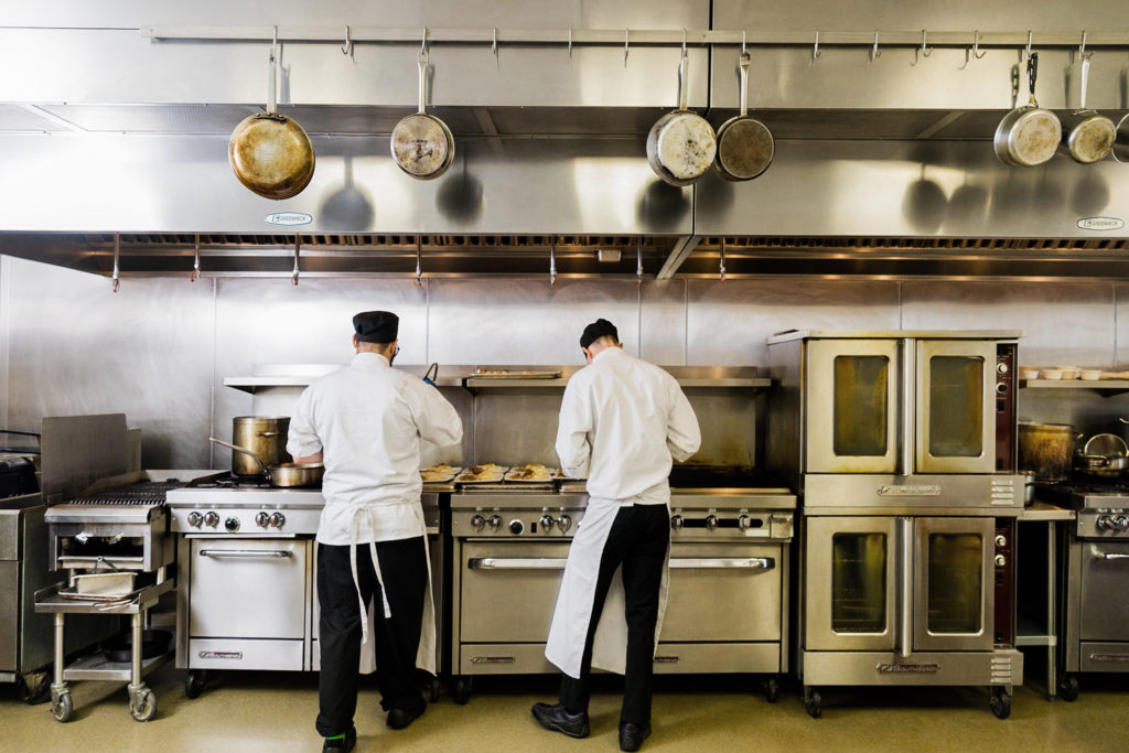 Escoffier Culinary Arts students preparing food in the professional classroom kitchen