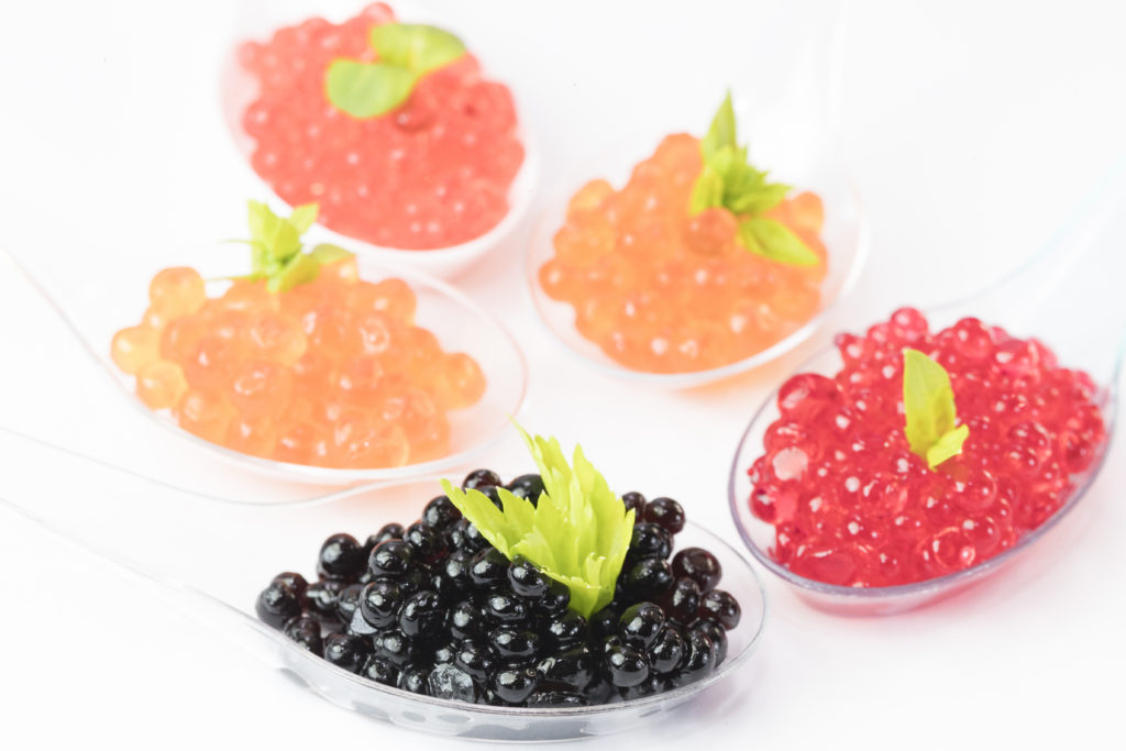 Molecular cuisine caviar elements shot closeup of a plastic buffet table spoon