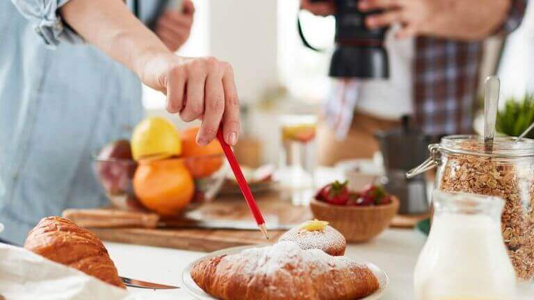 Close up of a hand pointing to a croissant