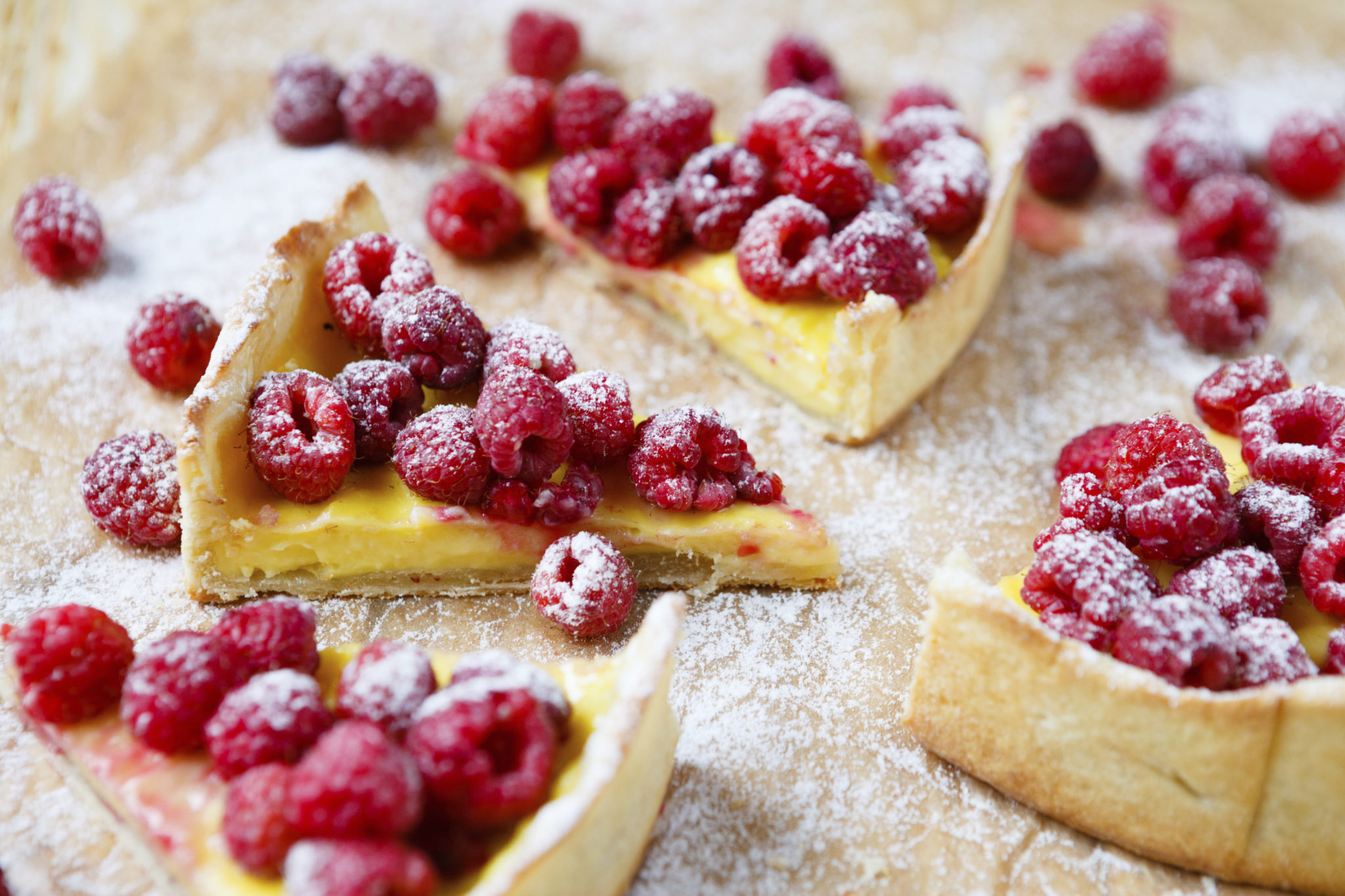 slices of cake with custard and raspberry