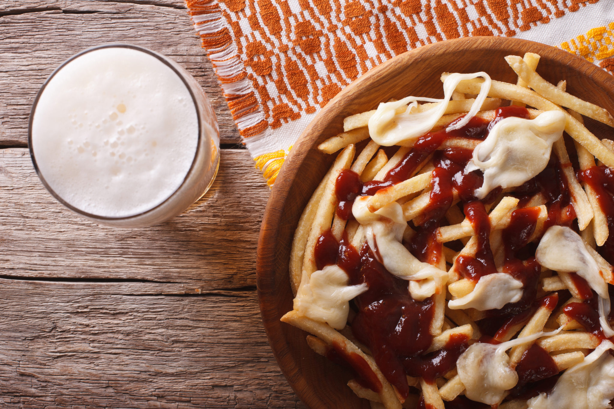 Canadian food: beer and fries with sauce close-up. horizontal to