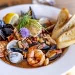 Bouillabaisse Seafood Soup Close-Up with Shrimp, Muscles, Clams, Fish, Fennel and Grilled Bread