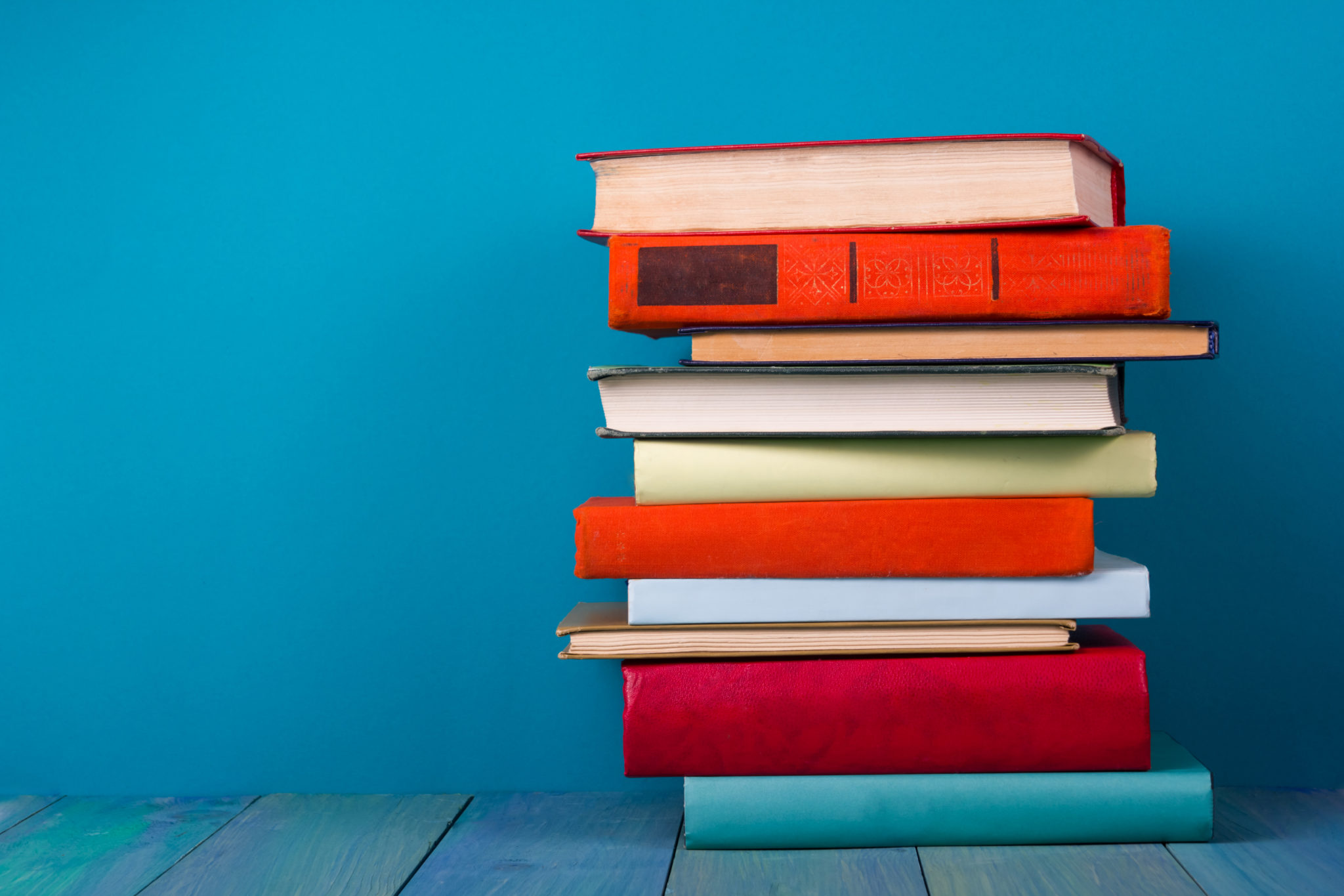 Stack of books in front of blue background