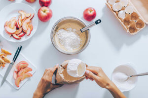 View from above of a chef pouring a cup of flour into a mixing bowl