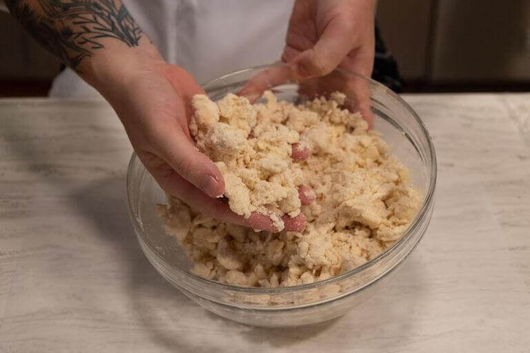 Flakey pie dough in a glass bowl