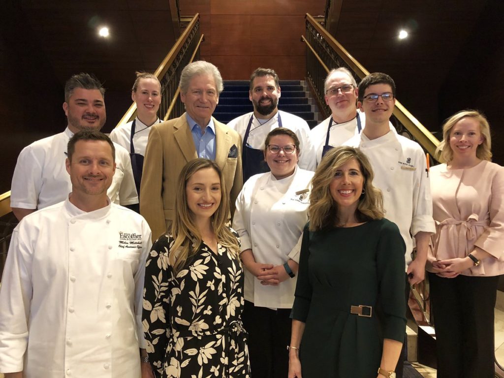 Great grandson of Auguste Escoffier, Michel Escoffier (second from left, second row) is surrounded by members of Auguste Escoffier School of Culinary Arts' leadership team and culinary leaders of The Ritz-Carlton, Denver recently in Denver, Colorado as part of the historic meeting celebrating the partnership of culinary and hospitality pioneers Cesar Ritz and Auguste Escoffier that started more than 130 years ago. 