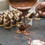 Melted chocolate being poured on nuts dessert
