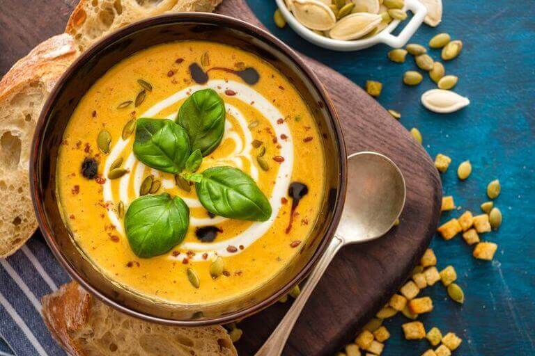 Pumpkin soup with basil leaves in a bowl