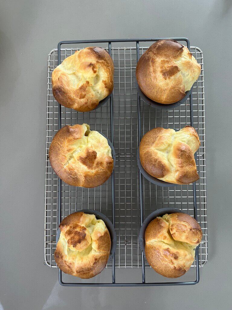 Six popovers on a cooling rack