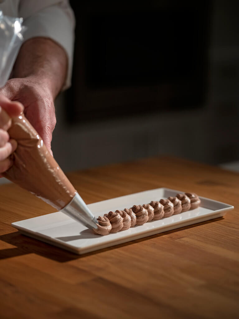 Chocolate Mousse being placed on a white plate