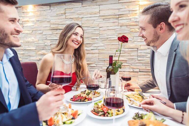 Four people sitting and eating outside at an upscale restaurant