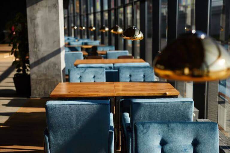 Interior of cafe with wooden tables and blue chairs