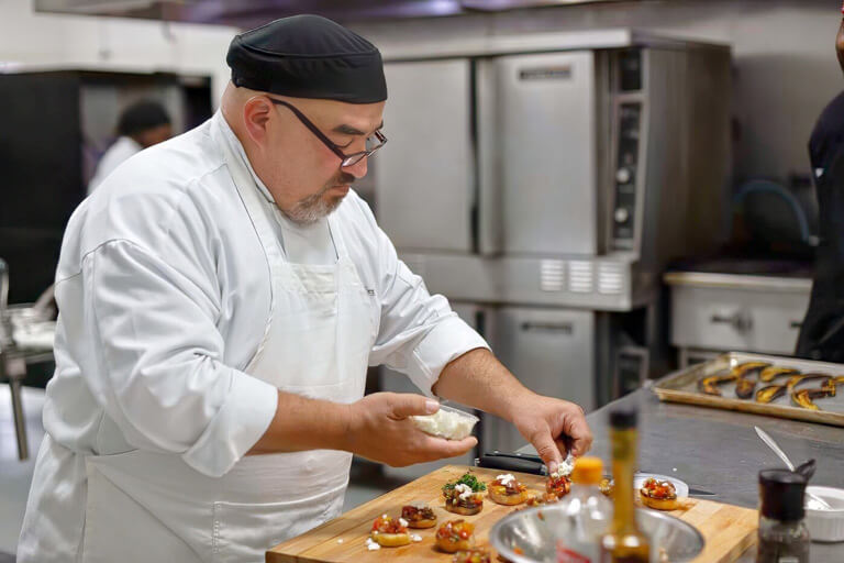 Student Adding Cheese to Bruschetta