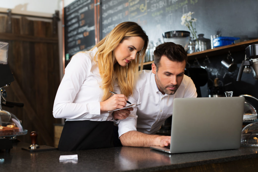 Two restaurant owners working with laptop