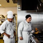 Female culinary student frying vegetables while chef instructor watches
