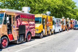 Food trucks on street by National Mall with cars driving by on Independence Avenue