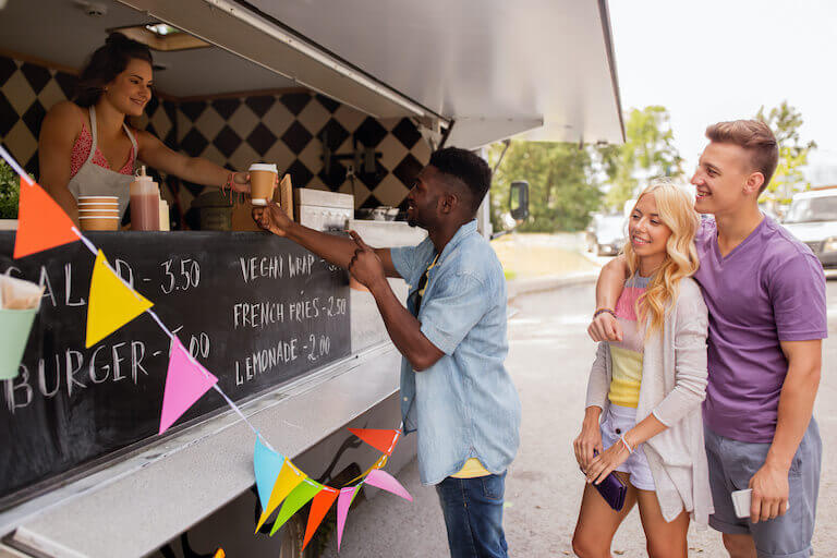 Smiling customers in line at a food truck