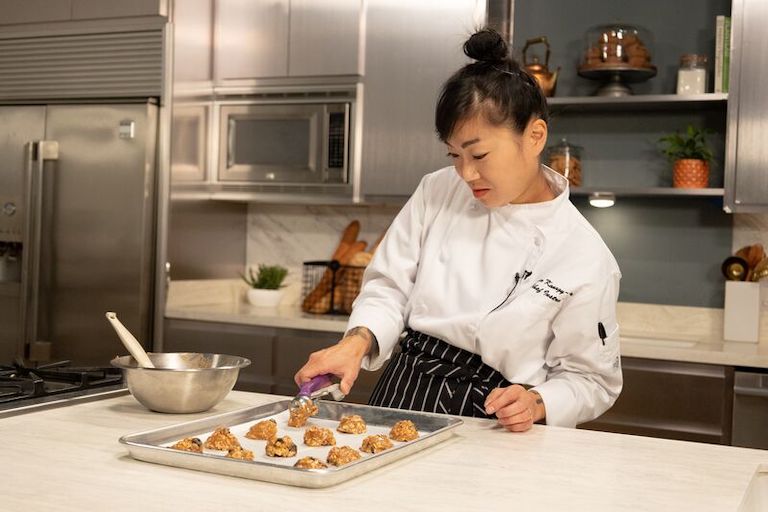 Baker placing oatmeal cookie dough on a baking tray