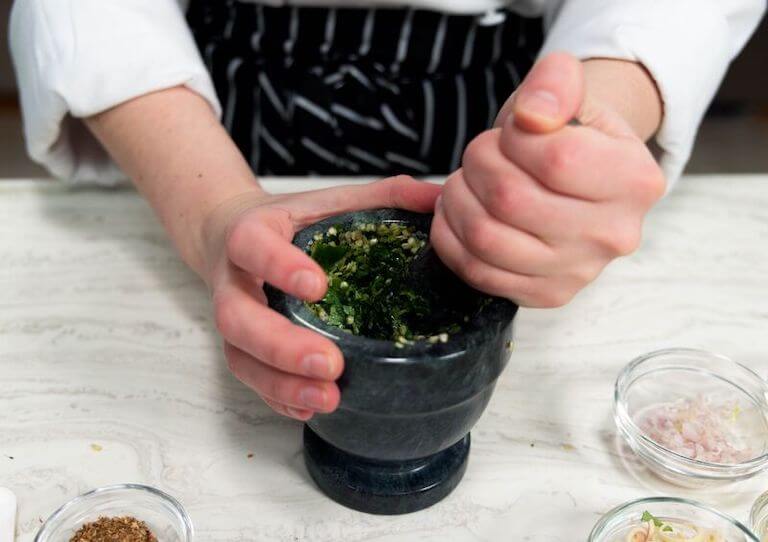 Chef mixing a green curry paste