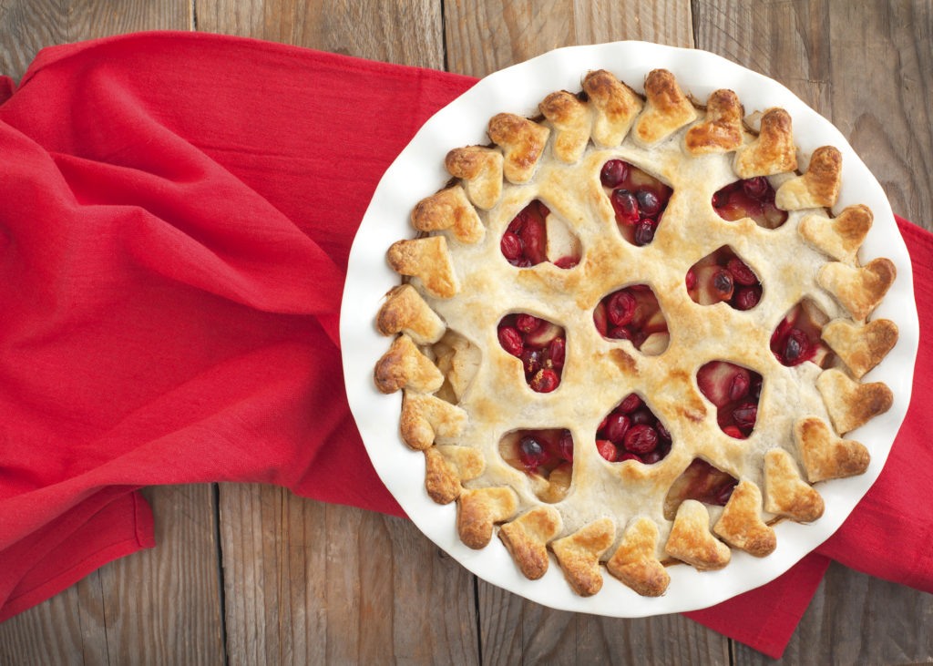 Cherry, apple, cranberry pie on top of a red scarf