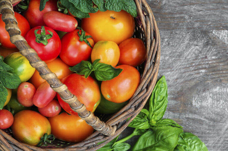 Brown basket with red tomatoes 