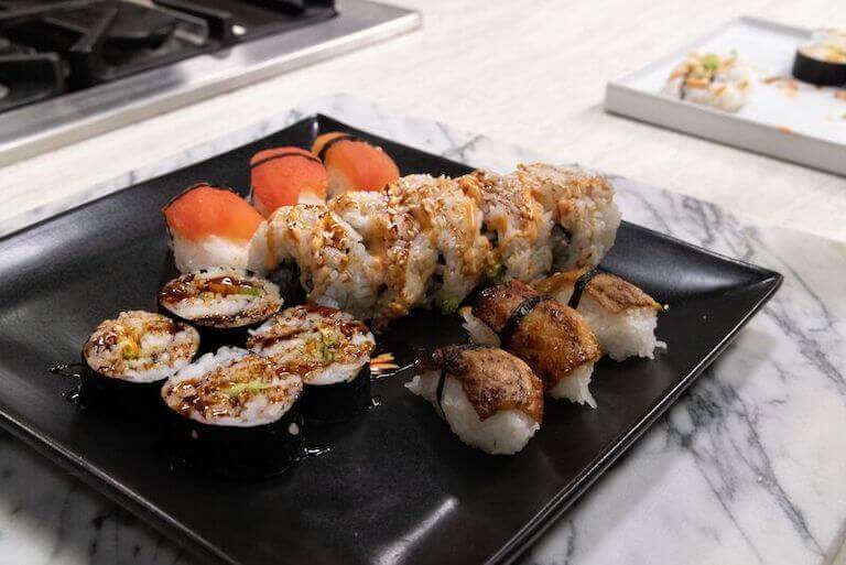 Plant based sushi with soy sauce on a black plate