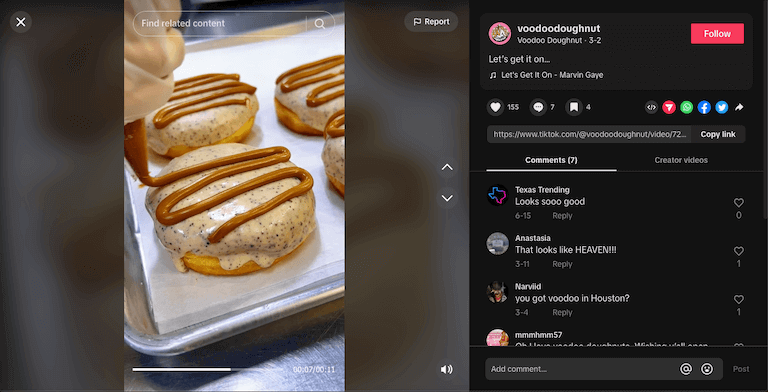 Screenshot of a TikTok post depicting a close-up image of an employee piping chocolate icing onto a row of doughnuts.