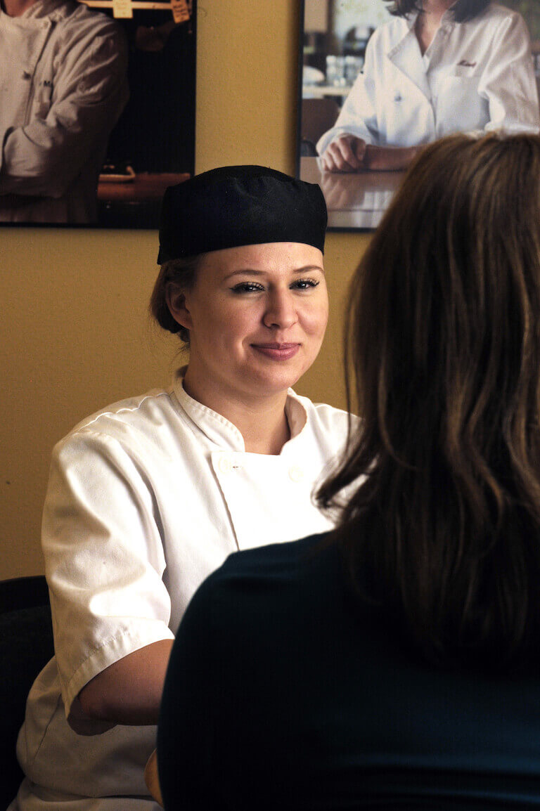 Smiling culinary student is talking with a financial aid advisor