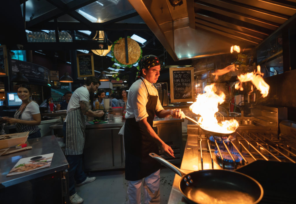 Chef with bandana with pan with flaming pan fire