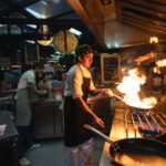 Chef with bandana with pan with flaming pan fire