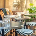 Charming outdoor sidewalk cafe in Paris, France with black and white chairs