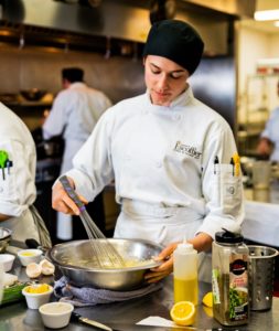 Female Escoffier student mixing and whisking a bowl