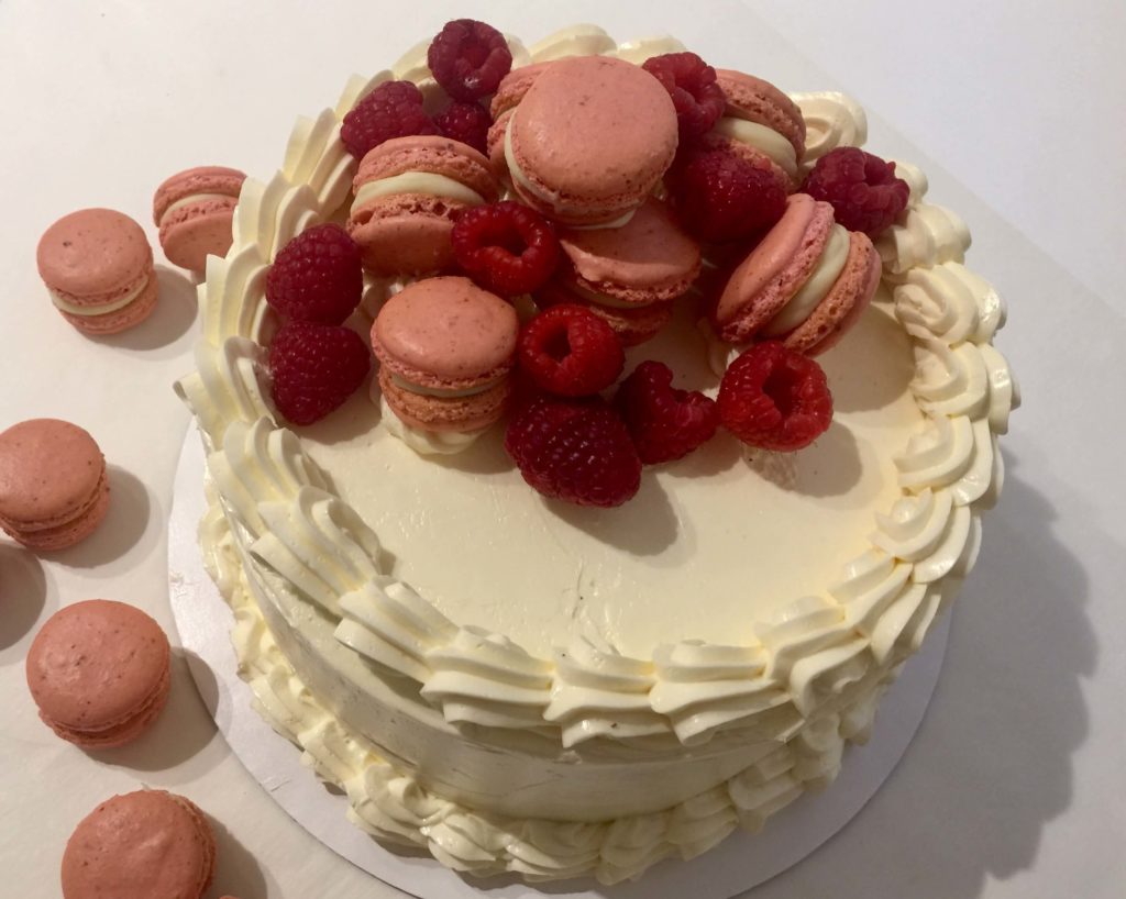 Golden Almond Butter Cake with White Chocolate Buttercream, Fresh Raspberries, and Raspberry Macarons \