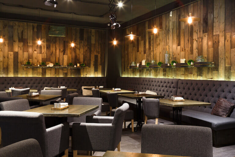 Interior of restaurant with wood walls and gray chairs