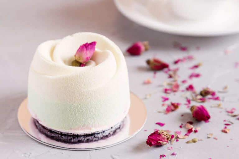 White and pink flower shaped dessert cake with petals