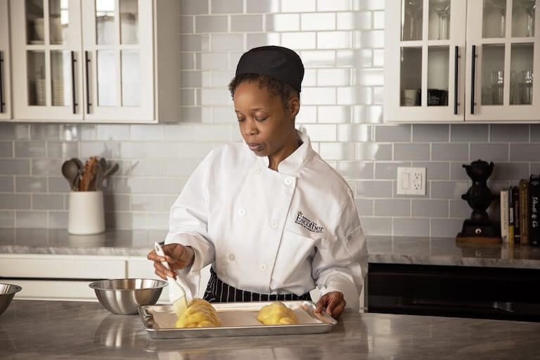 culinary student glazing dough in tray home kitchen