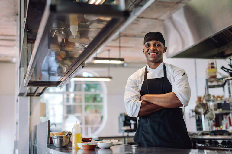 Smiling cook in a kitchen with an apron